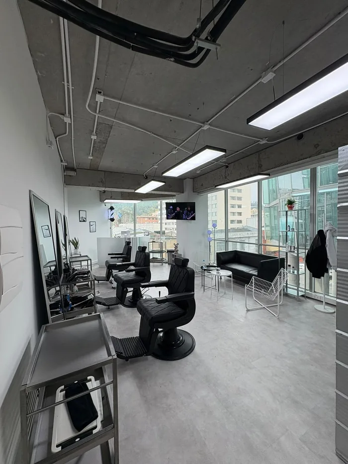 Sala de SW Studio con estaciones de barbería y espejos